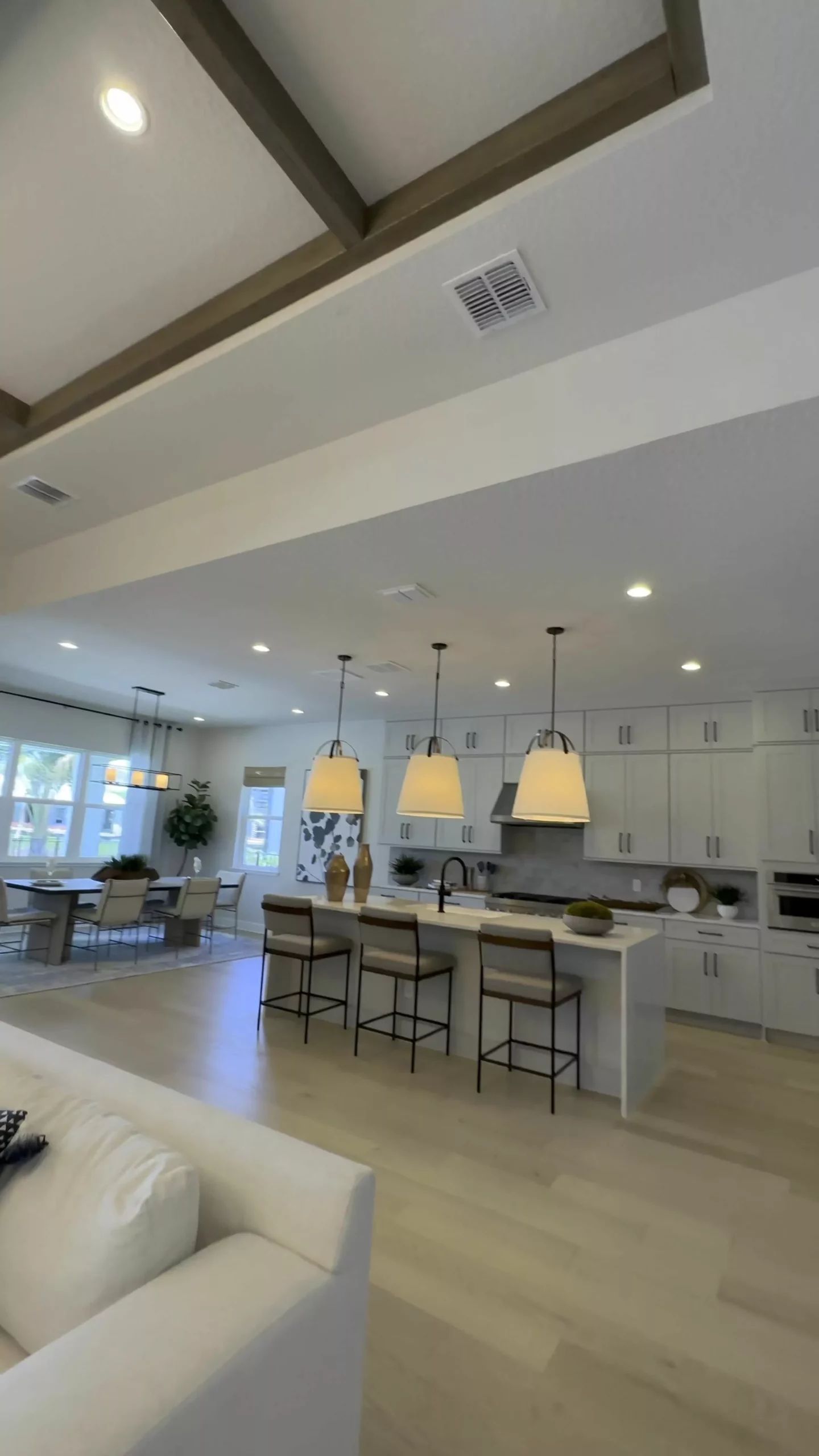 Discover the charm of this elegant kitchen with chic pendant lights, sleek cabinetry, and a spacious dining area perfect for gatherings.