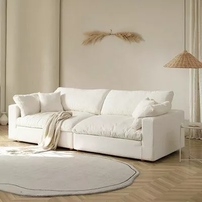 Discover the charm of a cozy, minimalistic living room with this plush white sofa, accent lighting, and simplistic decor. Perfect blend of comfort and style.