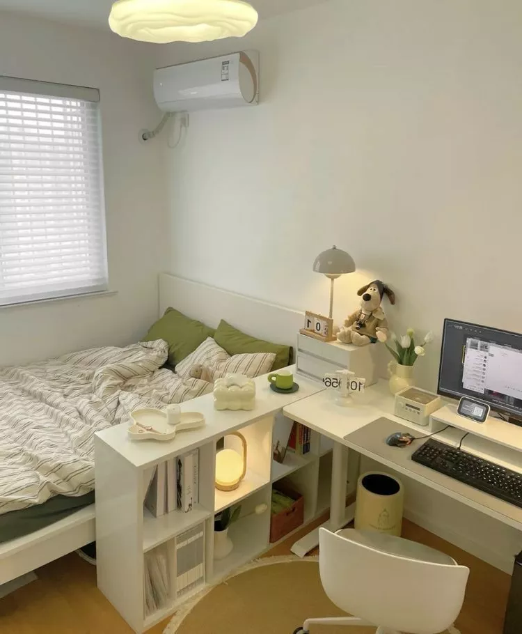 Discover the charm of this serene bedroom with a minimalist design, featuring a well-organized workspace and cozy decor elements.