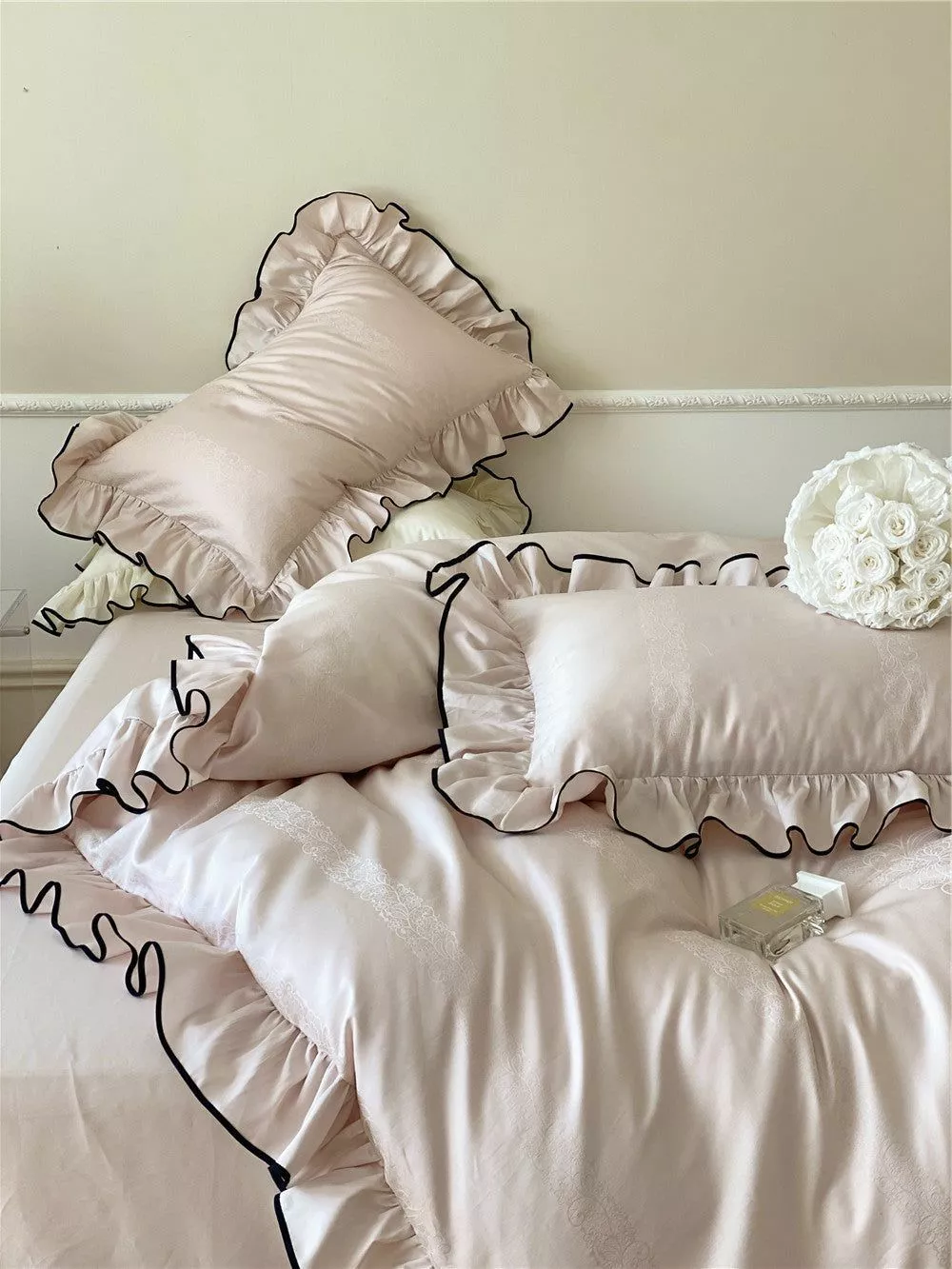 Transform your bedroom into a luxurious retreat with this elegant blush-colored bedding set featuring chic ruffled edges.