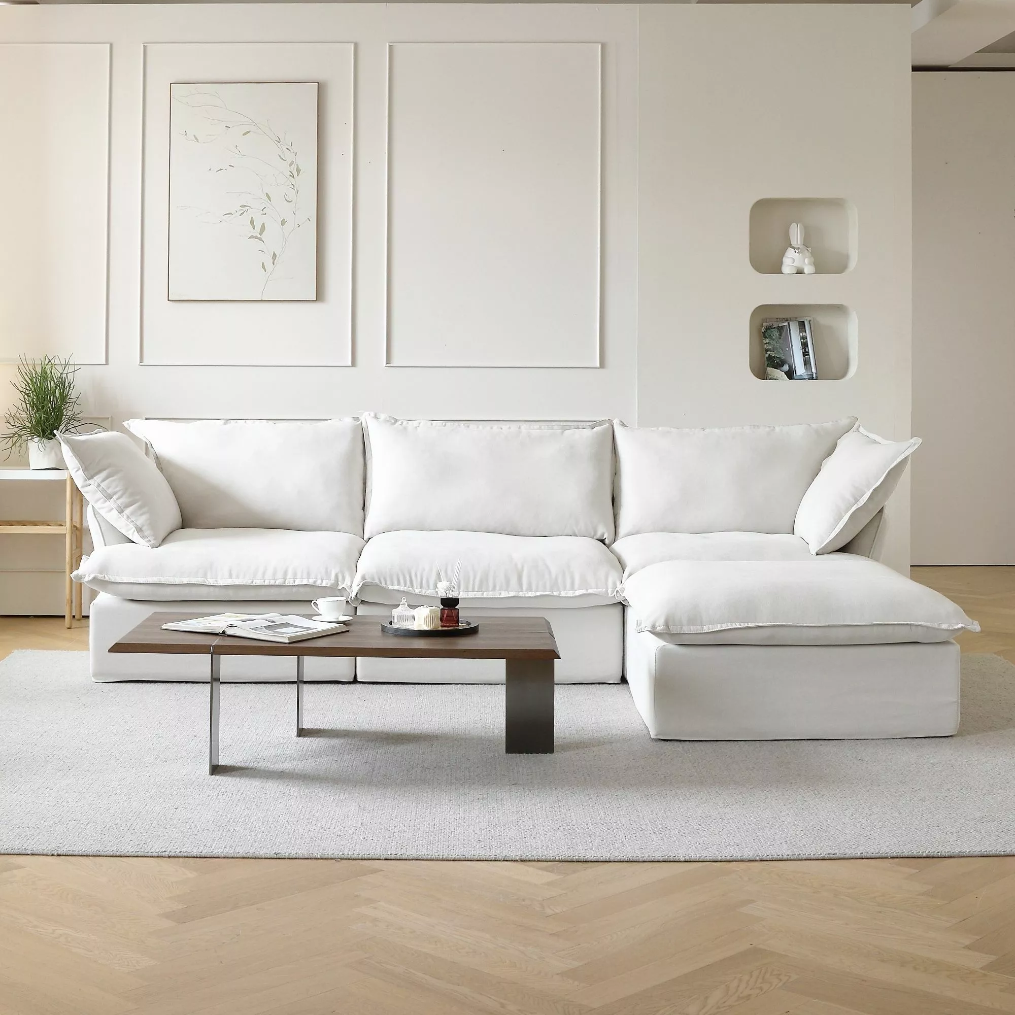 Discover the serene allure of this minimalist white living room setup featuring plush seating, artistic decor, and sleek furniture pieces.