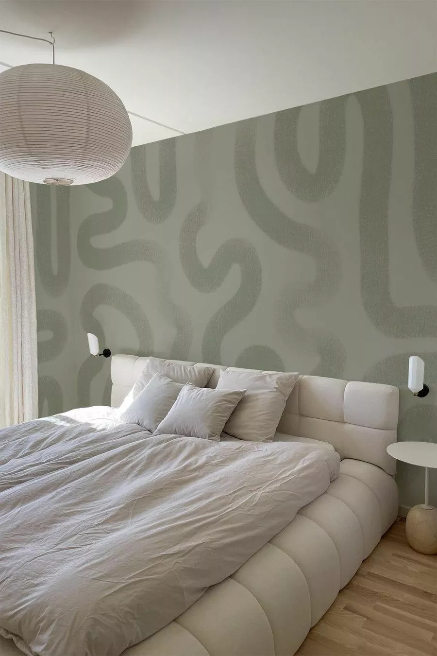 Discover serene elegance with serpentine wall patterns and plush white bedding in this modern bedroom oasis.