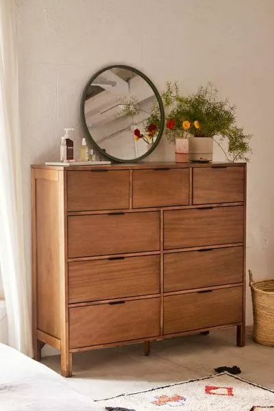 Discover the beauty of rustic elegance with this wooden dresser. Featuring a mirror and vibrant flowers, it’s ideal for your home décor.