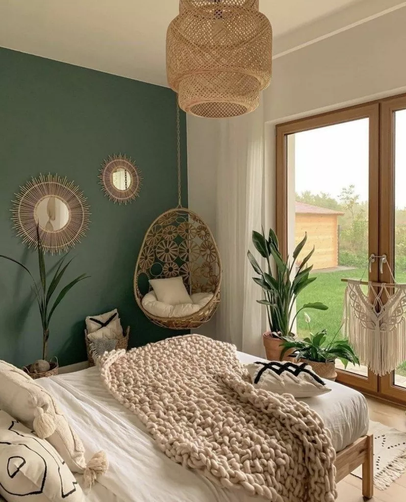 Step into this serene green-themed bedroom with a boho-chic vibe, featuring a cozy knitted blanket and nature-inspired decorations.