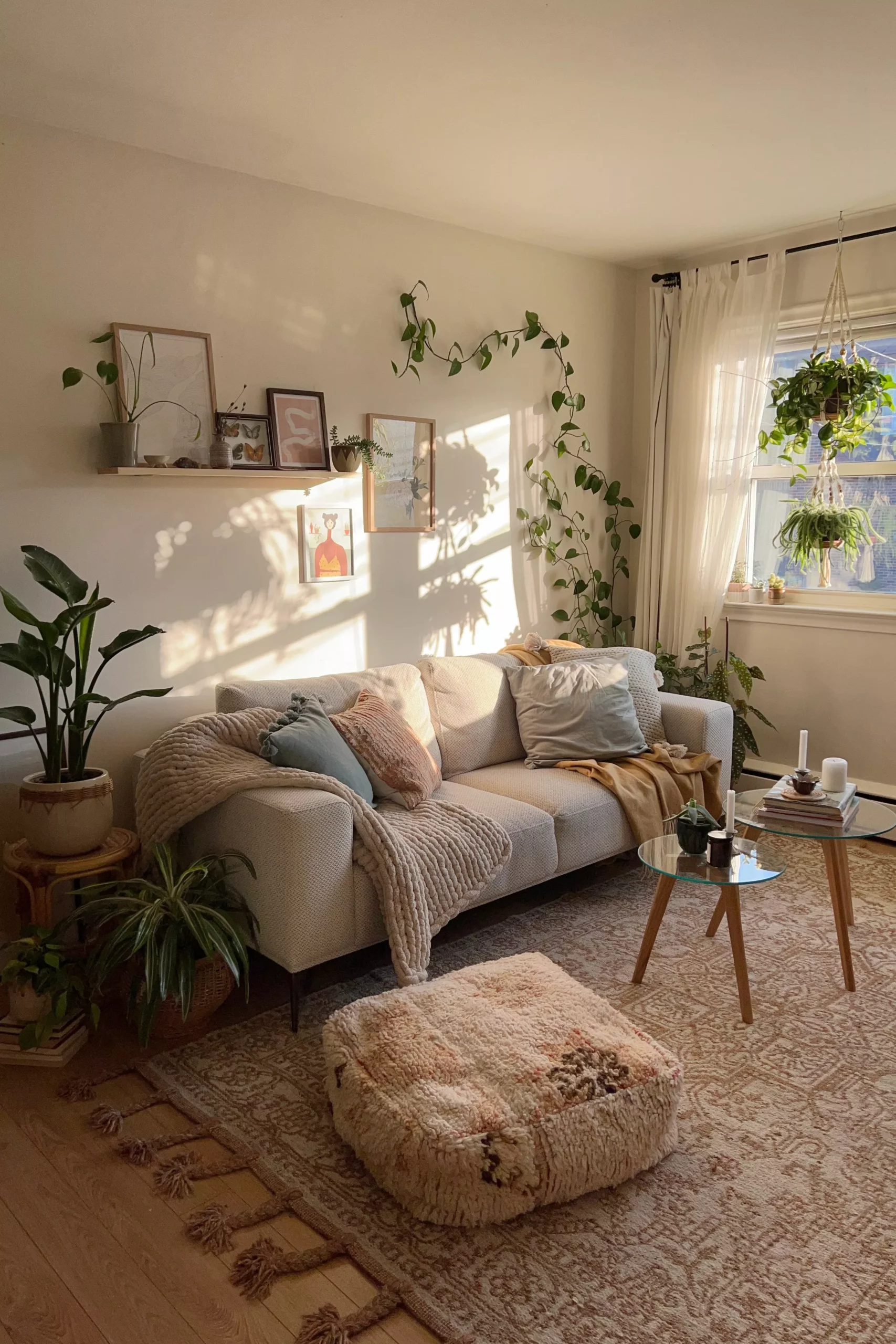 Experience tranquility and style with our serene boho living room design, featuring lush greenery, comfy textures, and warm, inviting decor elements.