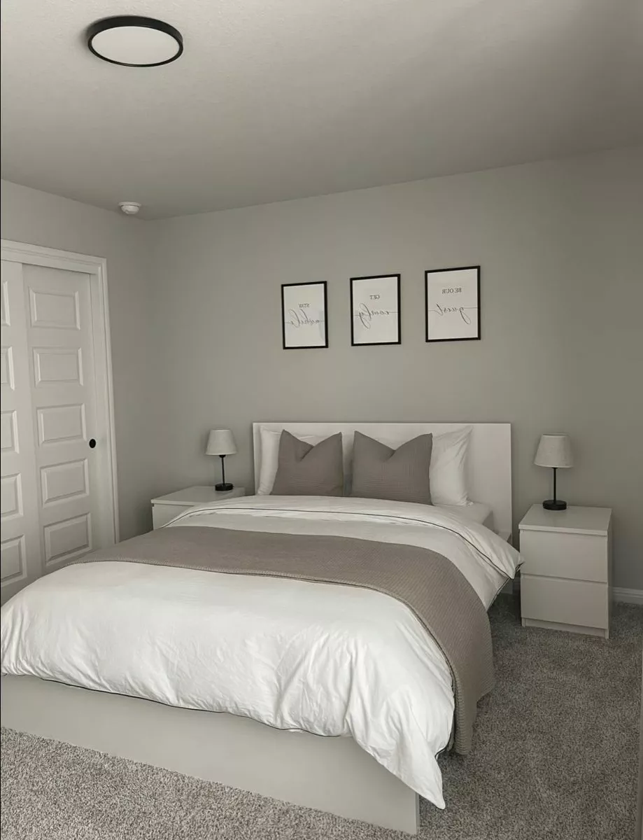 Explore this serene modern bedroom haven with elegant artwork, minimalist furniture, and cozy neutral tones for a chic and restful ambiance.