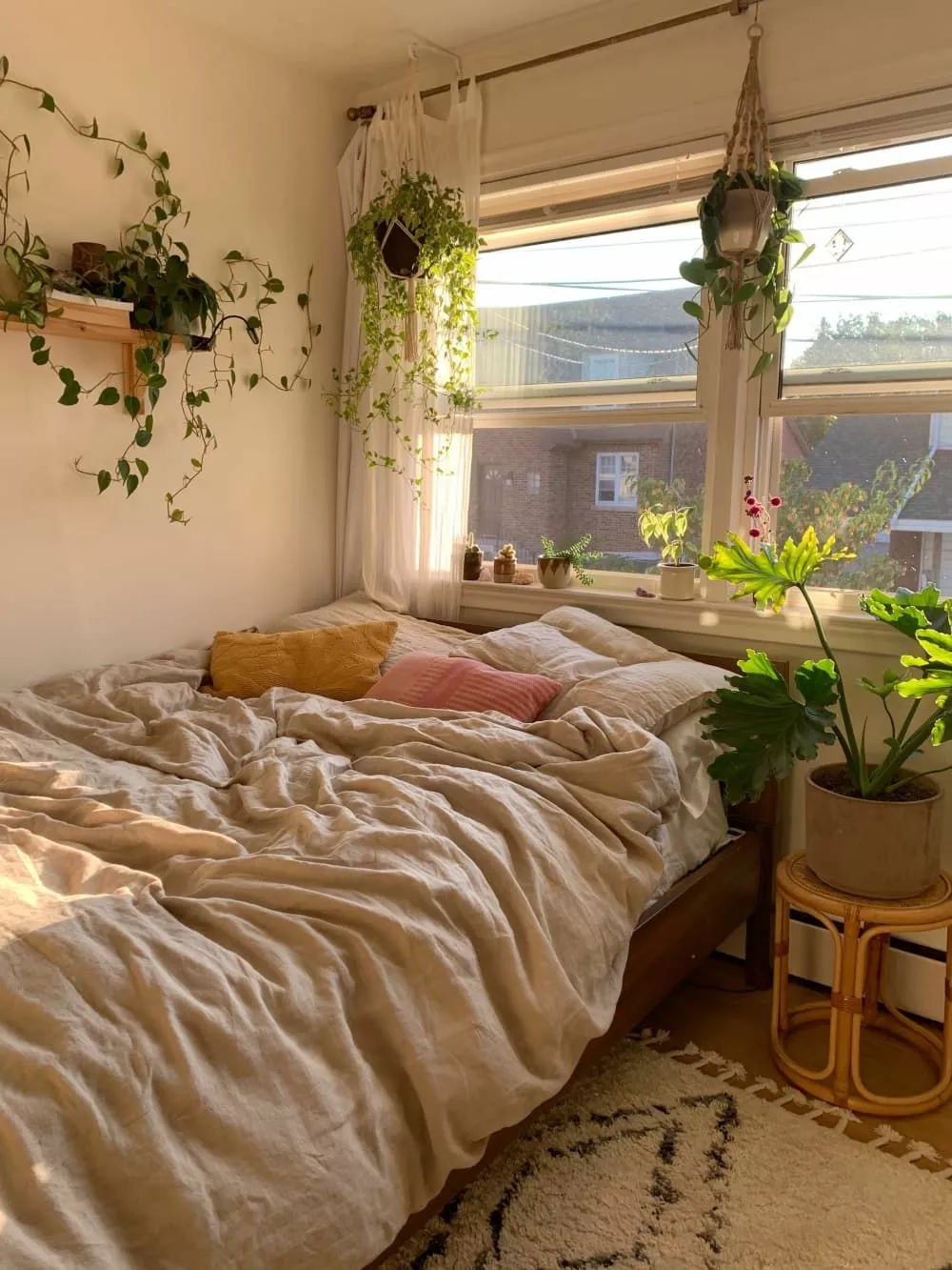 This cozy bedroom features lush greenery, soft textiles, and warm sunlight, creating a perfect sanctuary for relaxation.