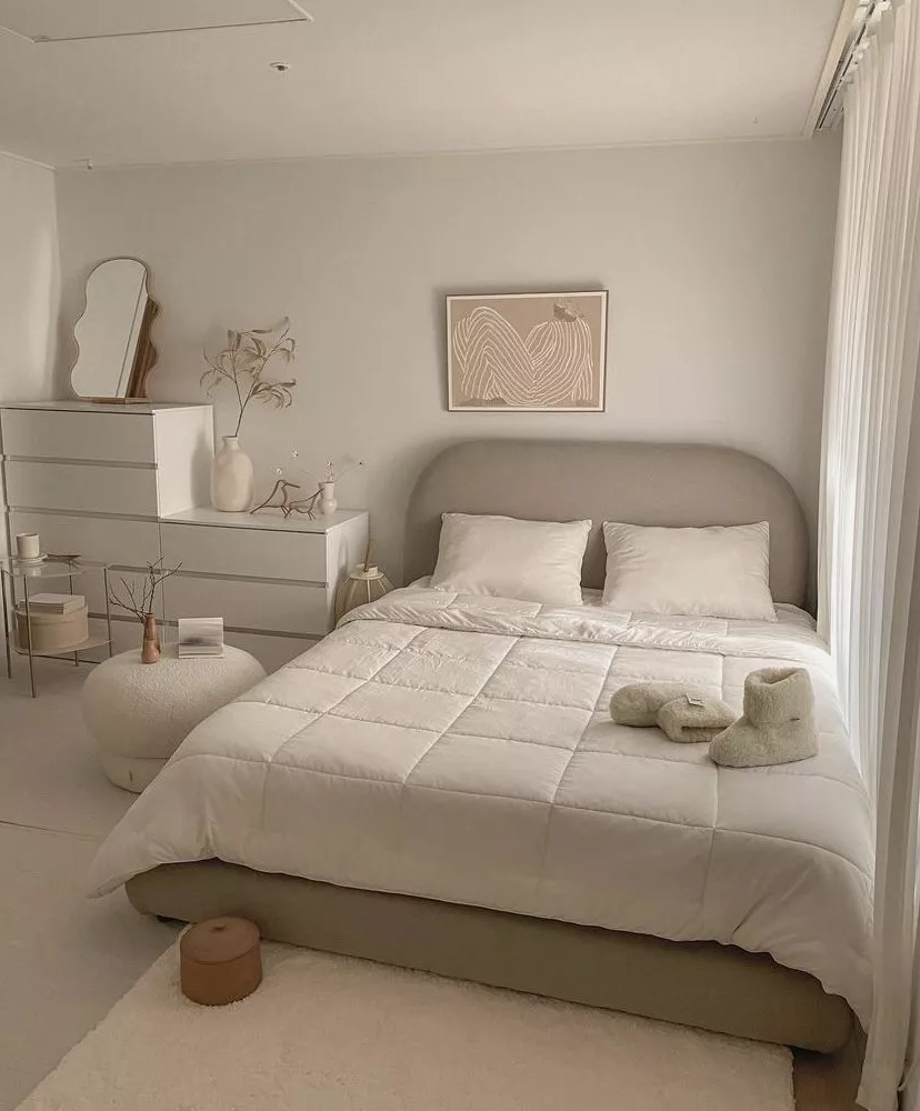 Explore the beauty of minimalist design with muted tones, cozy textures, and artful décor in this serene bedroom setup.