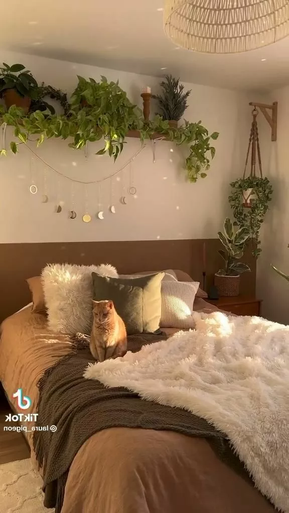 Discover a cozy boho bedroom featuring lush greenery, textured fabrics, and a cute cat enjoying the serene ambiance.