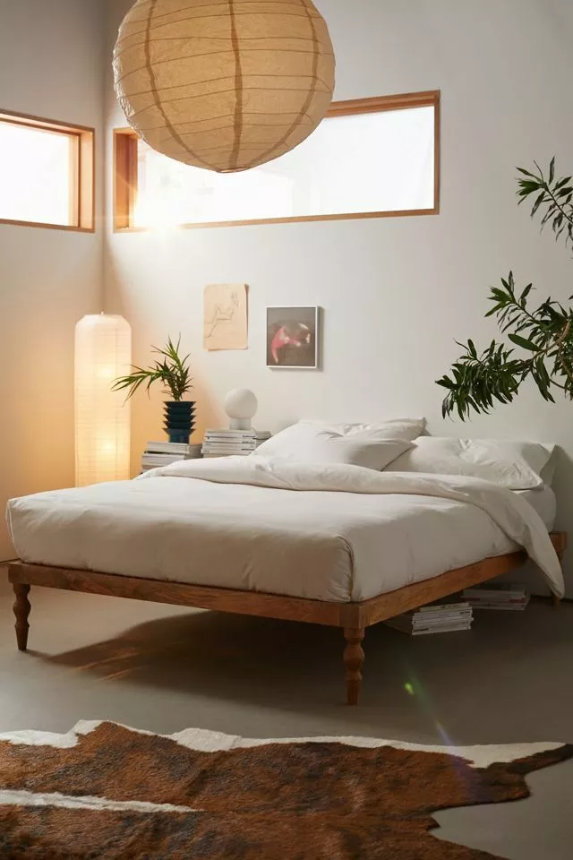 Discover a serene bedroom setup with minimalist decor, lush greenery, and warm lighting for an ultimate relaxation experience.